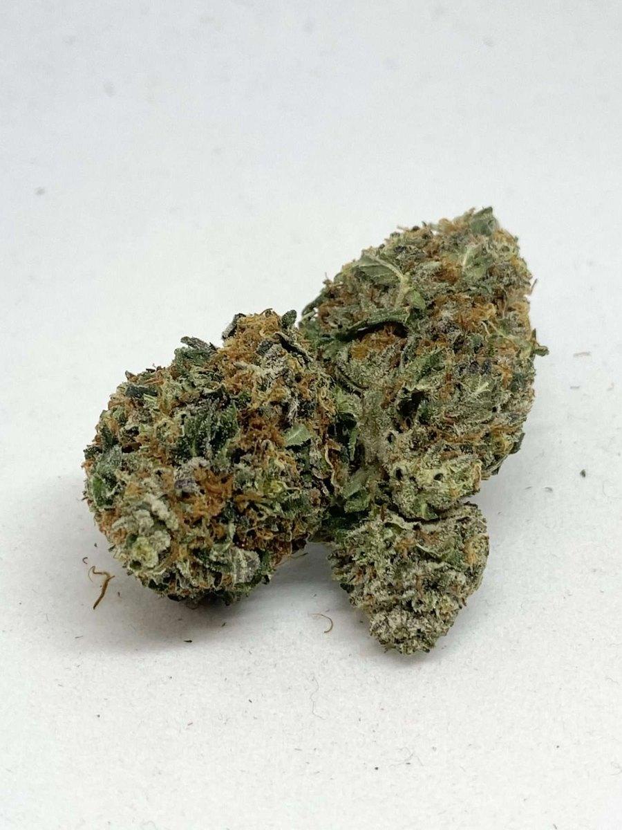 Grape Ape AAA indica cannabis flower bud, dense frosty nug with orange pistils, THC 17-23%